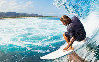 man surfing just off the the island